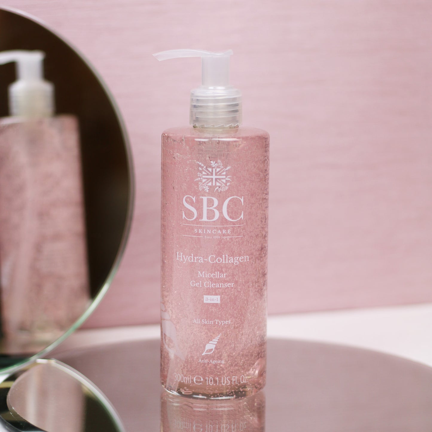 Hydra-Collagen Micellar Gel Cleanser on a round mirror on pink background