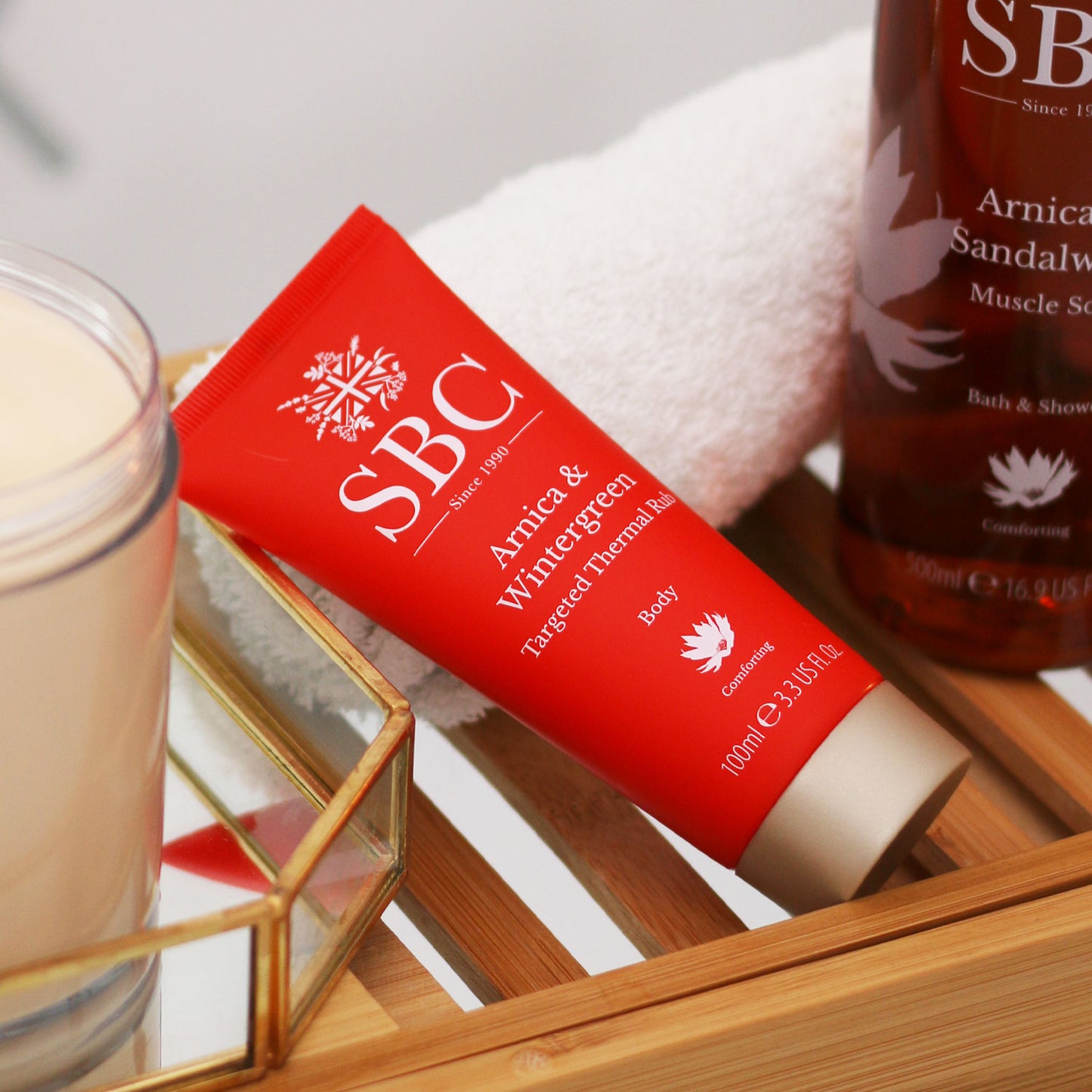 Arnica & Wintergreen Targeted Thermal Rub on a wooden towel caddy