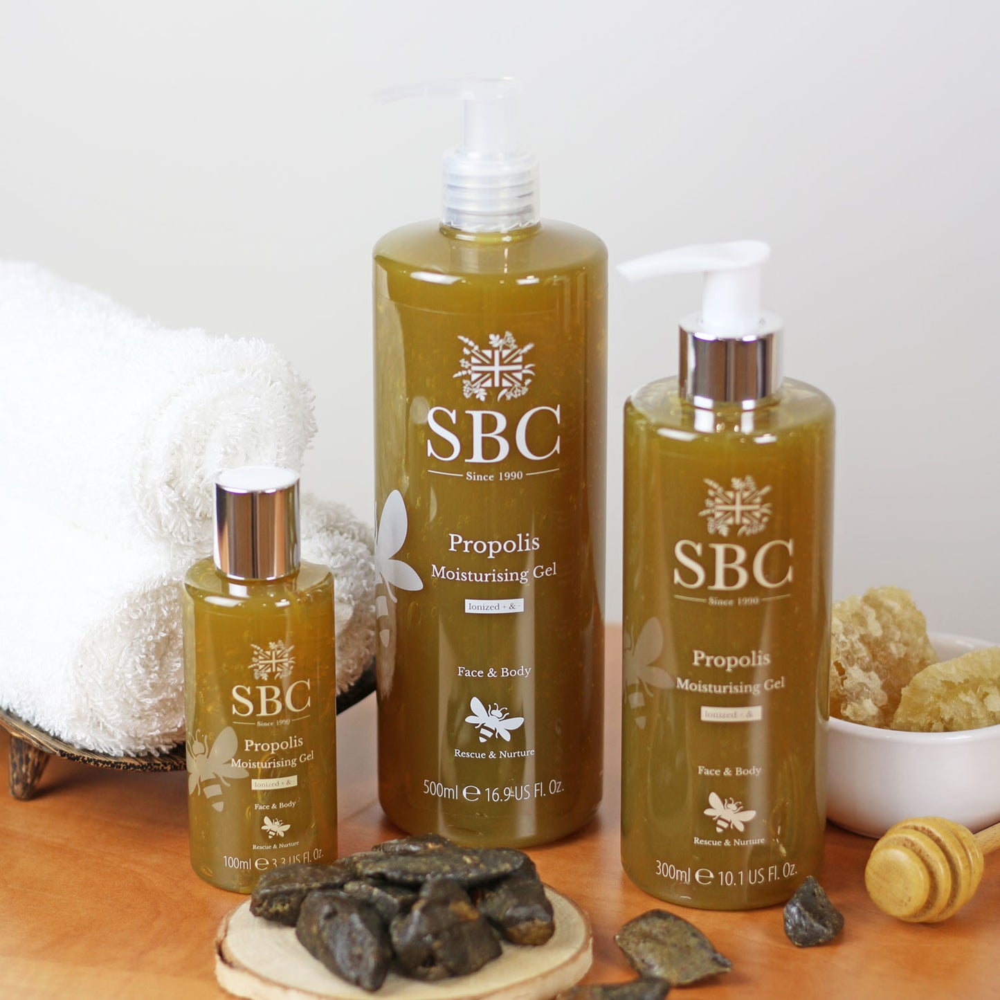 100ml, 300ml and 500ml Propolis Moisturising Gel on a wooden board with honey combs and propolis extract