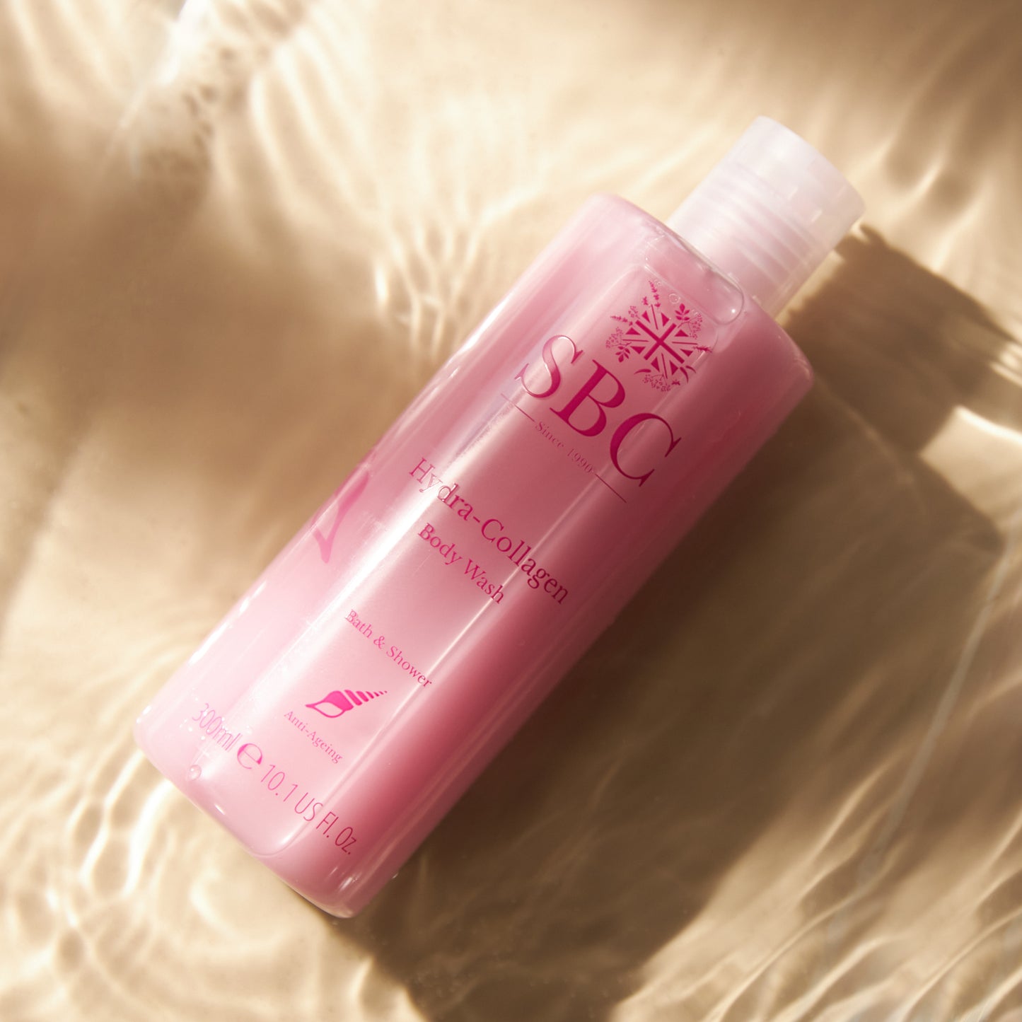 300ml of SBC Skincare's Hydra-Collagen Body Wash laying in a pool of water