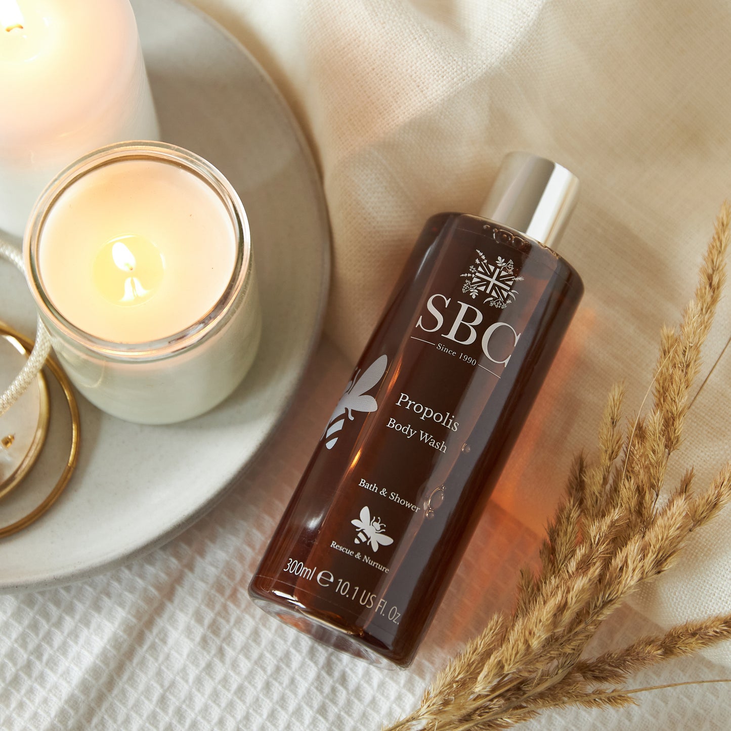 Propolis Body Wash, with a candle and dried flowers
